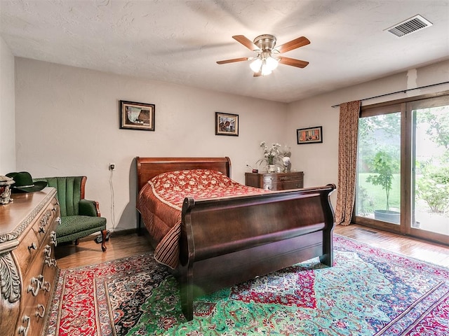 bedroom featuring ceiling fan, wood-type flooring, and a textured ceiling