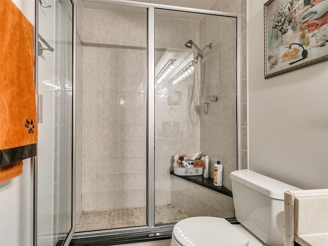 bathroom featuring toilet and an enclosed shower