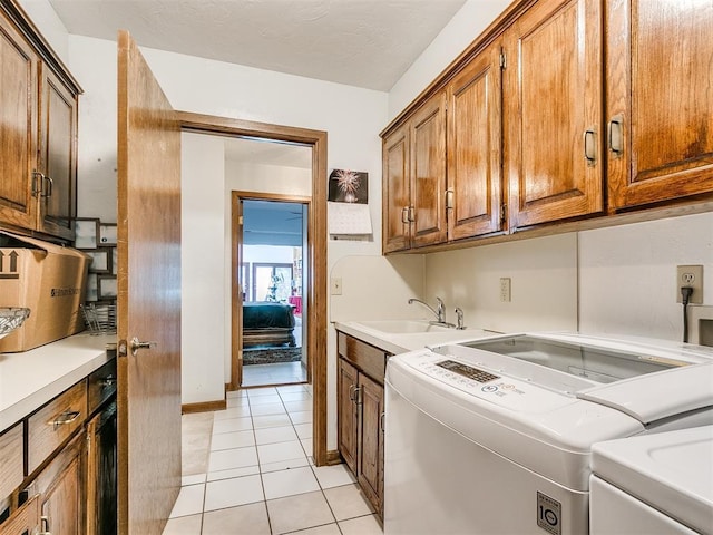 washroom featuring cabinets, separate washer and dryer, sink, and light tile patterned floors