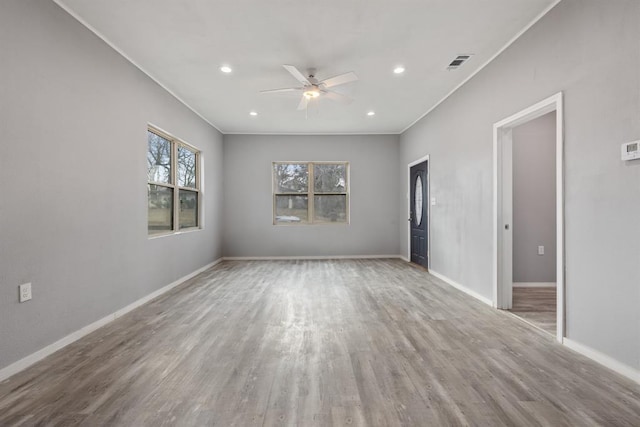 empty room with crown molding, ceiling fan, and wood-type flooring