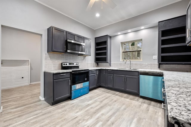 kitchen featuring sink, light stone counters, light wood-type flooring, ceiling fan, and stainless steel appliances