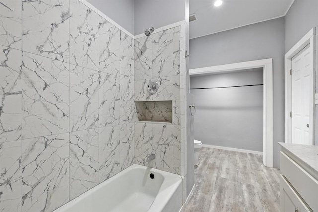 full bathroom featuring vanity, tiled shower / bath combo, toilet, and hardwood / wood-style flooring