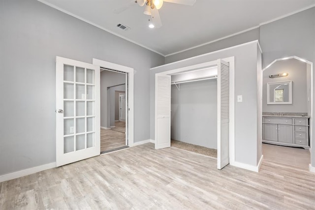 unfurnished bedroom featuring sink, light wood-type flooring, ornamental molding, a closet, and ceiling fan