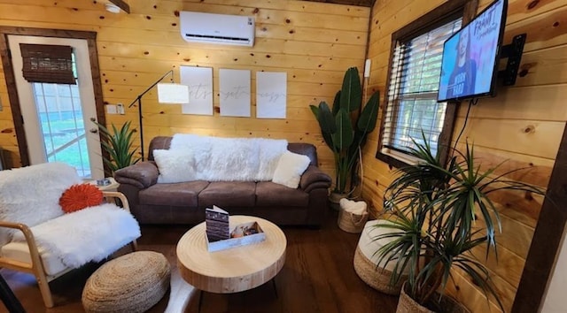 living room with hardwood / wood-style floors, wooden walls, and an AC wall unit