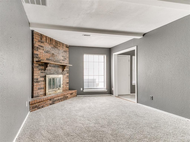 unfurnished living room with a brick fireplace, light carpet, and beam ceiling