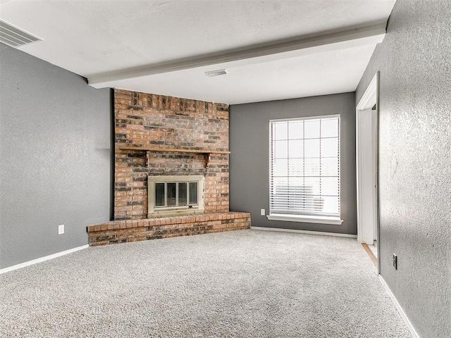 unfurnished living room featuring beam ceiling, a fireplace, and light colored carpet