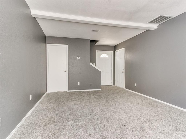 spare room featuring beamed ceiling and carpet