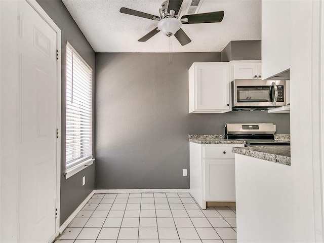 kitchen featuring ceiling fan, stainless steel appliances, light stone countertops, a textured ceiling, and white cabinets