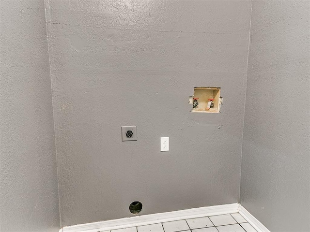 washroom featuring electric dryer hookup, light tile patterned floors, and washer hookup