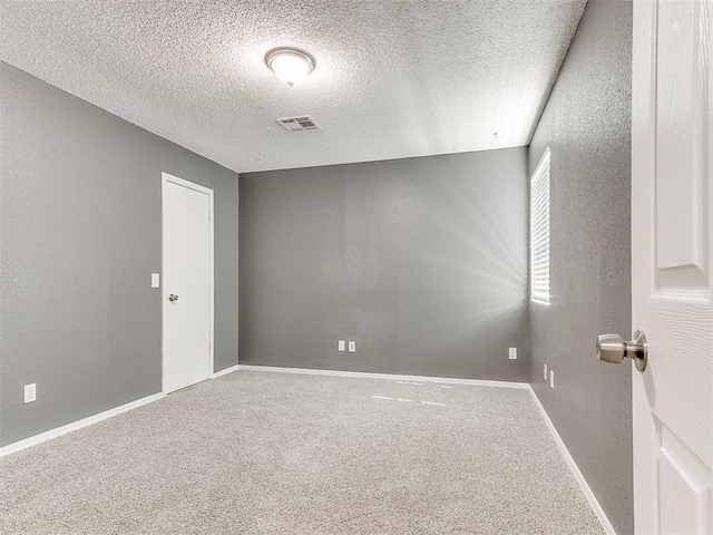 carpeted spare room with a textured ceiling