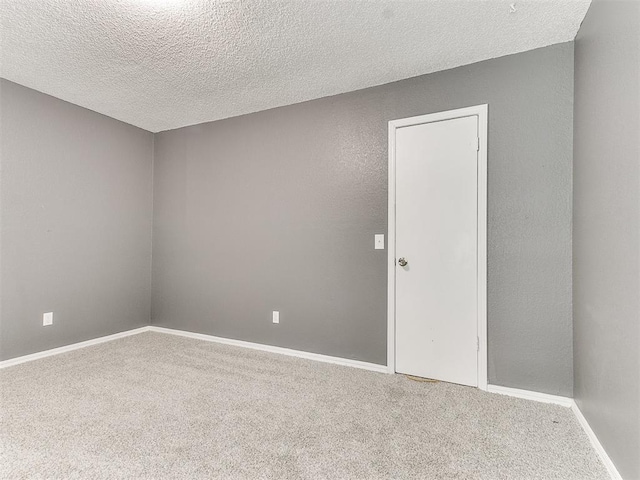 carpeted spare room with a textured ceiling