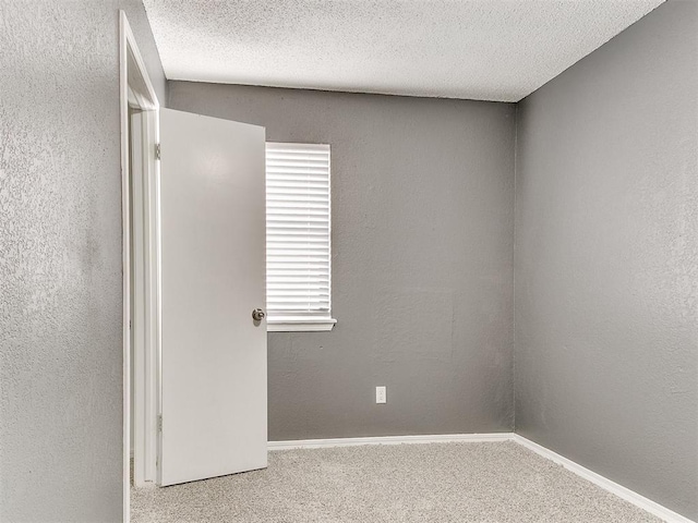 carpeted empty room with a healthy amount of sunlight and a textured ceiling