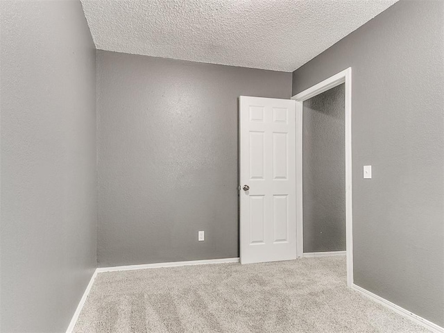 carpeted spare room with a textured ceiling