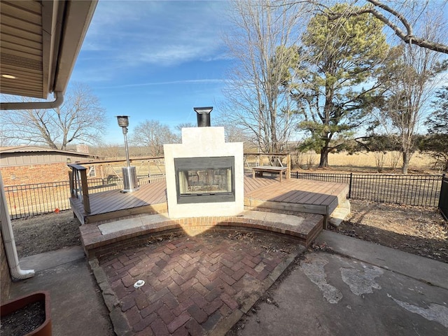 view of patio featuring exterior fireplace and a wooden deck