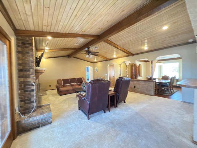 carpeted living room featuring lofted ceiling with beams, decorative columns, a fireplace, and wood ceiling