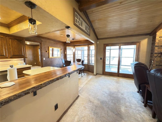 kitchen featuring lofted ceiling, butcher block countertops, wood ceiling, decorative light fixtures, and light colored carpet