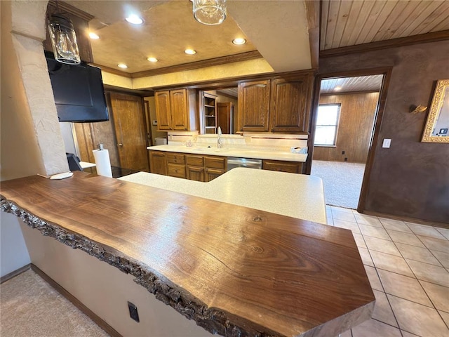 kitchen featuring dishwasher, sink, kitchen peninsula, a raised ceiling, and light carpet