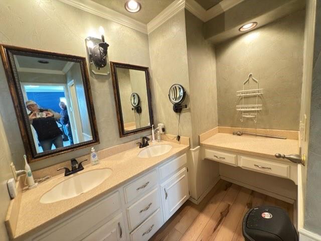 bathroom with vanity, hardwood / wood-style floors, and crown molding