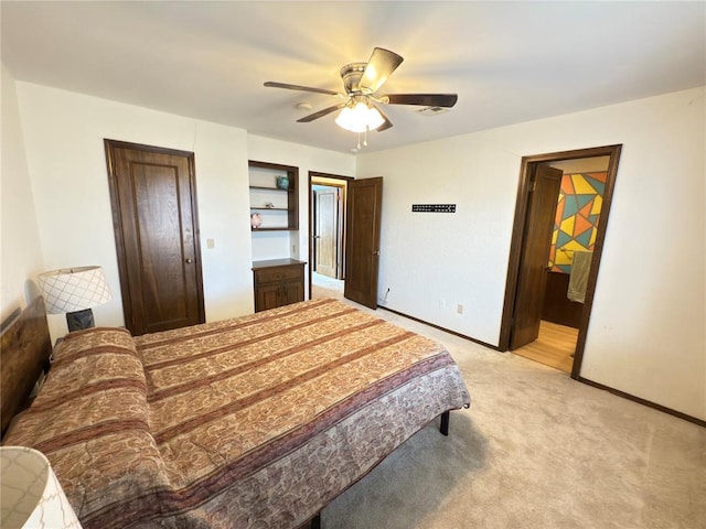 carpeted bedroom with ceiling fan and ensuite bath