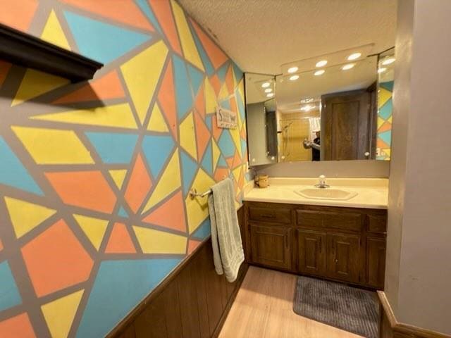 bathroom featuring vanity, hardwood / wood-style flooring, and a textured ceiling