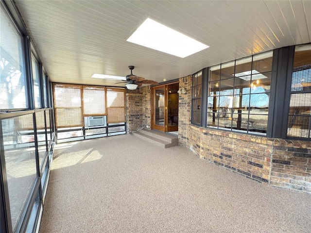 unfurnished sunroom featuring ceiling fan and a skylight