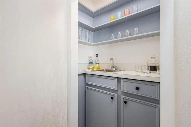 bar featuring sink and gray cabinetry