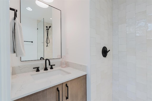 bathroom with vanity and tiled shower