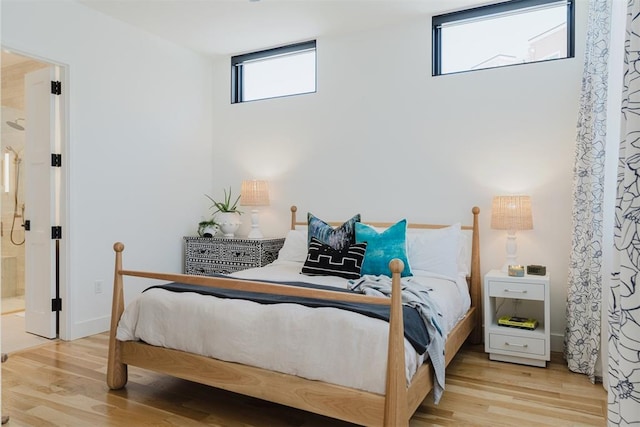 bedroom featuring ensuite bathroom and light hardwood / wood-style flooring