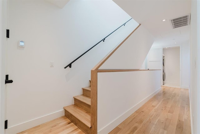 staircase with hardwood / wood-style floors