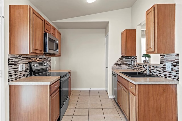 kitchen featuring appliances with stainless steel finishes, sink, light tile patterned floors, and lofted ceiling