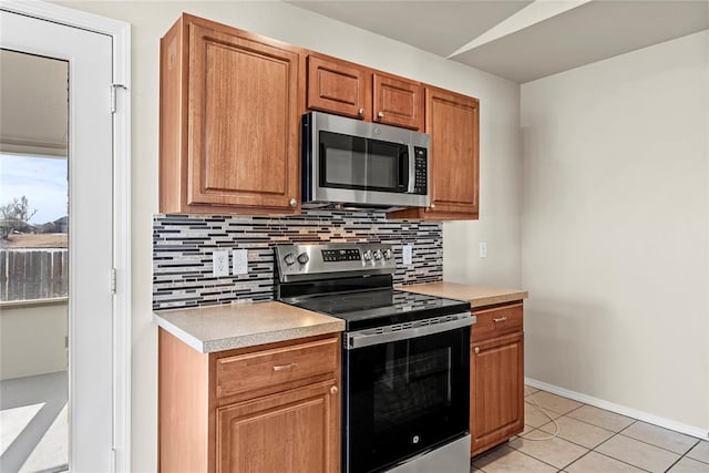 kitchen featuring light tile patterned flooring, stainless steel appliances, and backsplash