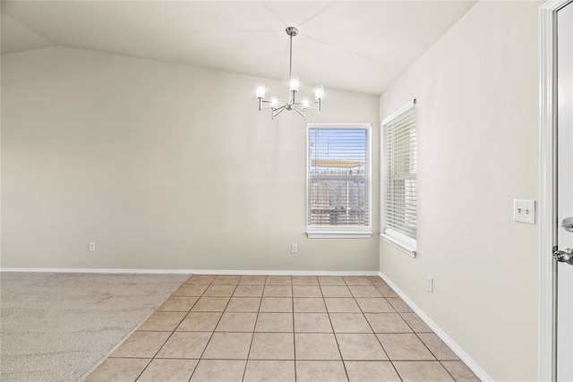 spare room featuring light tile patterned flooring, an inviting chandelier, and vaulted ceiling