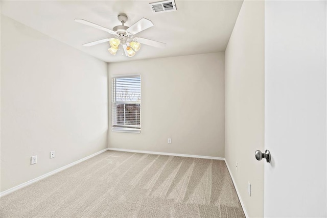 spare room featuring light colored carpet and ceiling fan