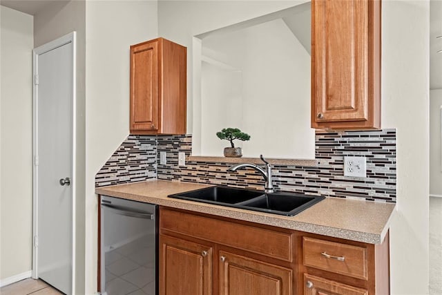 kitchen with a sink, light countertops, backsplash, stainless steel dishwasher, and light tile patterned flooring