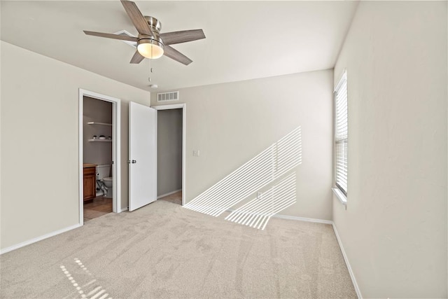 unfurnished bedroom featuring ensuite bath, visible vents, baseboards, and carpet floors