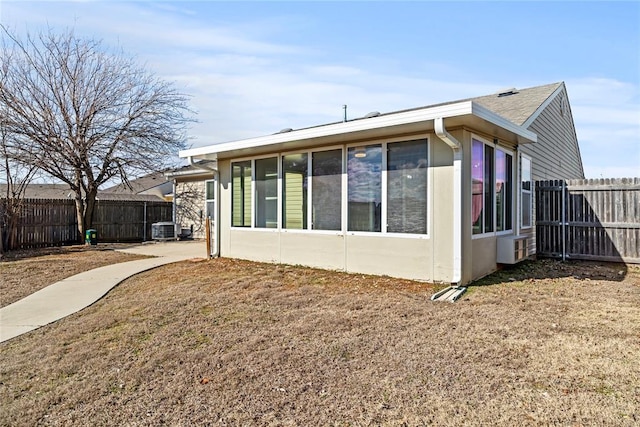 rear view of house featuring a fenced backyard and central air condition unit