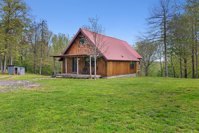 view of front of house with a storage shed, a front lawn, and covered porch