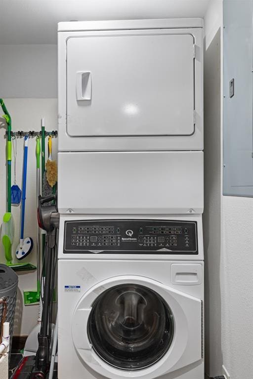 clothes washing area featuring stacked washing maching and dryer