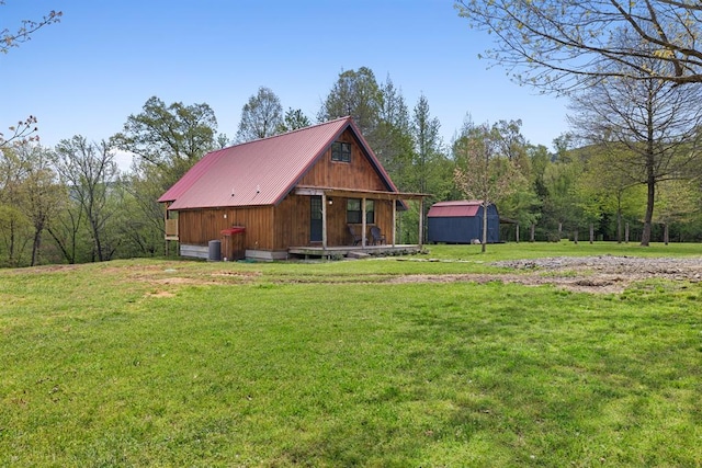 rear view of property with a storage shed and a lawn