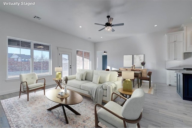 living room with ceiling fan and light wood-type flooring