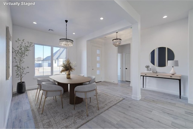 dining room with an inviting chandelier and light wood-type flooring