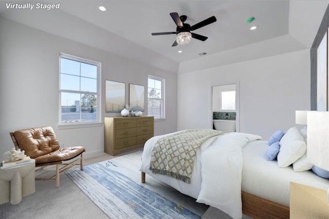 bedroom featuring multiple windows, carpet, ceiling fan, and a tray ceiling