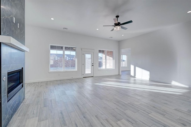 unfurnished living room with a fireplace, light hardwood / wood-style floors, and ceiling fan