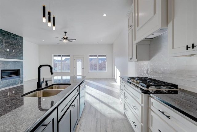 kitchen with sink, stainless steel appliances, hanging light fixtures, and white cabinets