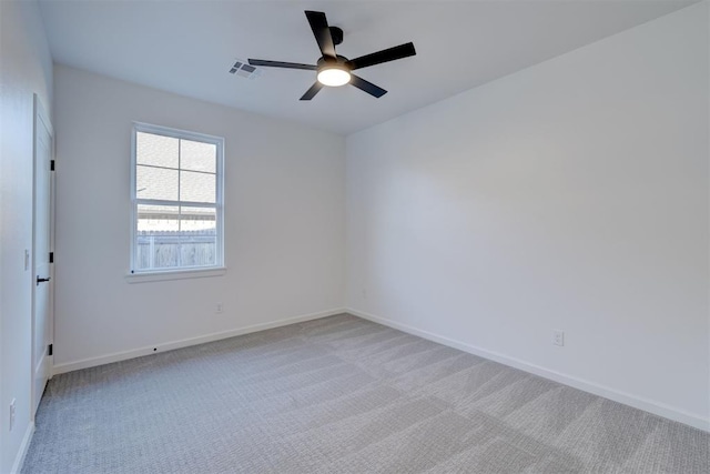 spare room featuring light colored carpet and ceiling fan