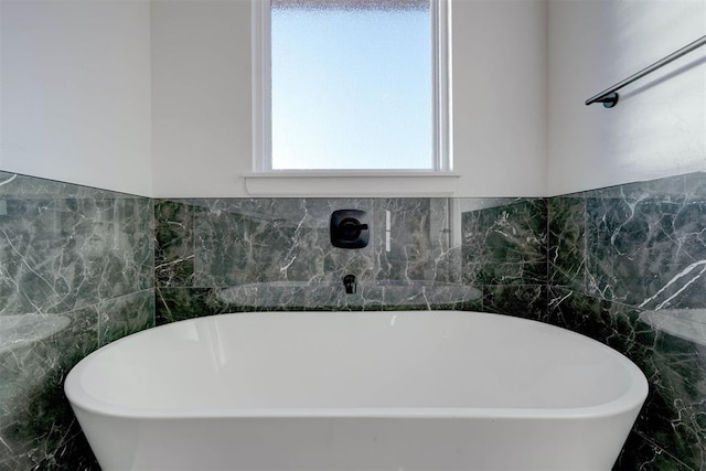 bathroom featuring tile walls and a bathtub