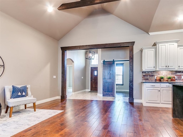 kitchen with backsplash, dark hardwood / wood-style floors, a barn door, and white cabinets