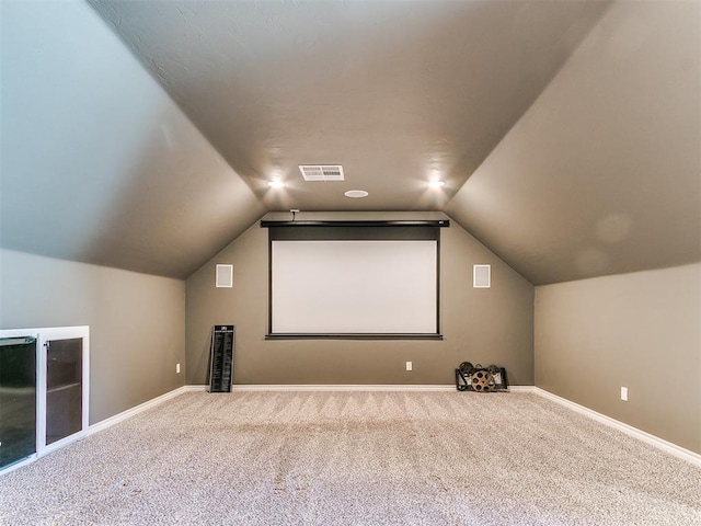 cinema room with lofted ceiling and carpet floors