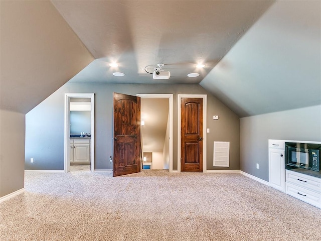 additional living space with vaulted ceiling and light carpet