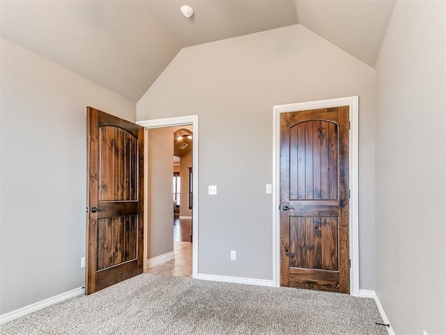 unfurnished bedroom with lofted ceiling and light colored carpet